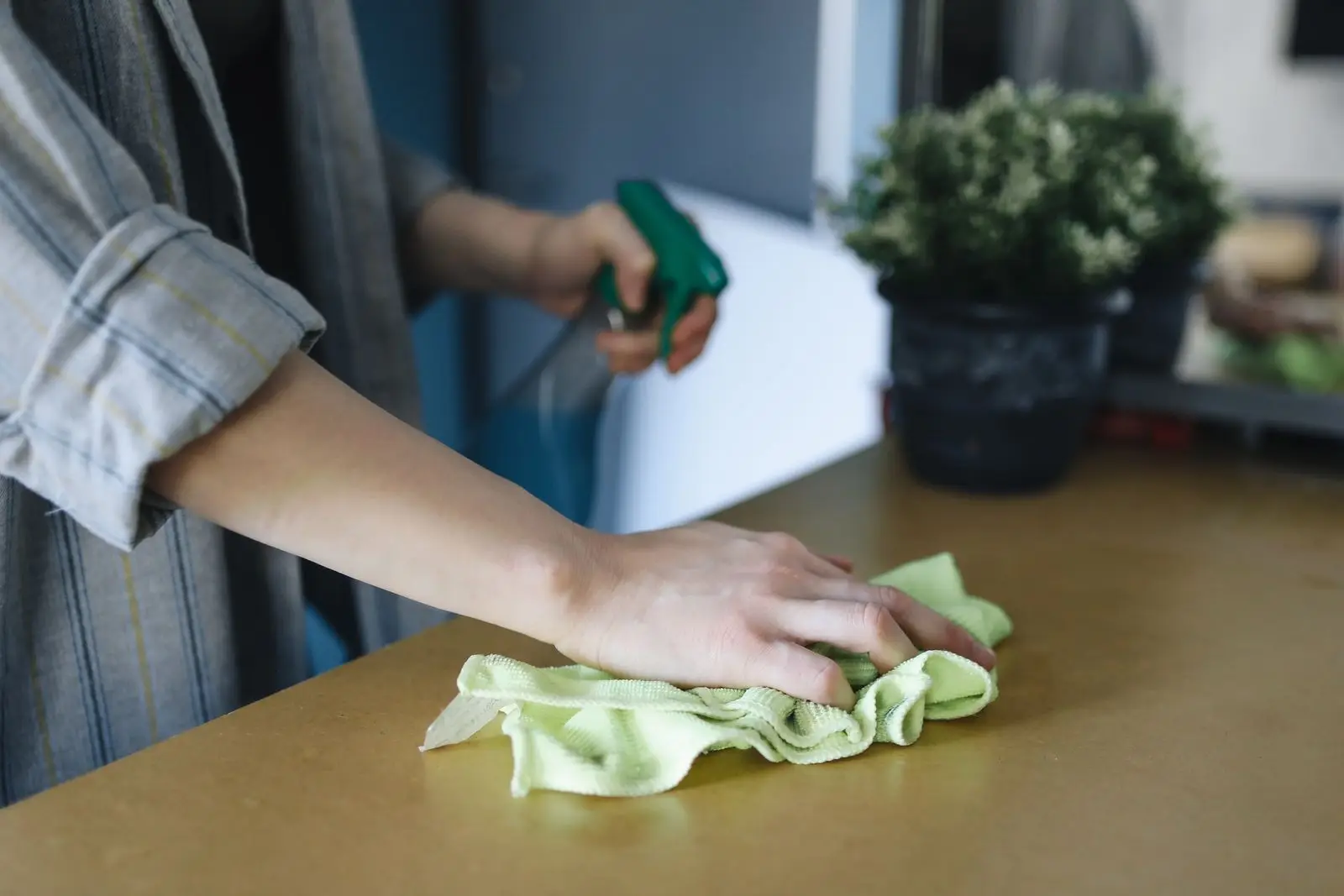 Nettoyage d'un plan de travail à domicile, chiffon et spray à la main